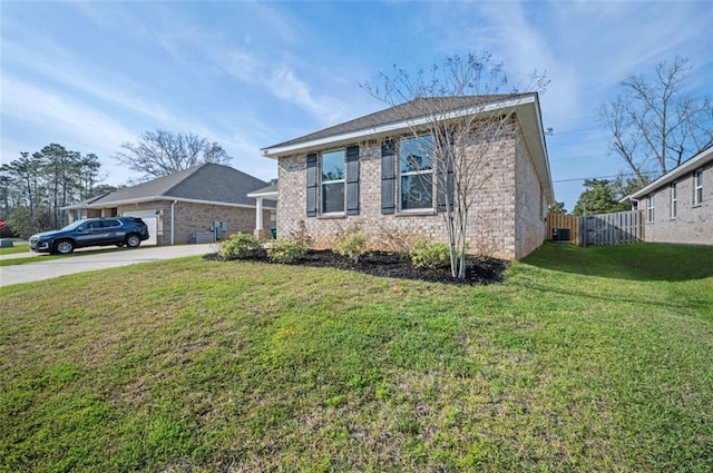 view of front facade featuring fence, driveway, an attached garage, a front lawn, and brick siding