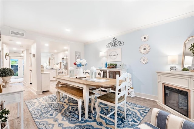 dining area featuring crown molding and light hardwood / wood-style flooring