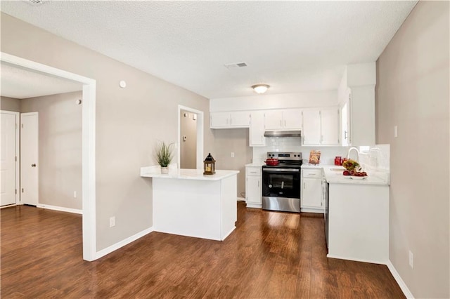 kitchen featuring stainless steel electric stove, white cabinetry, sink, decorative backsplash, and dark wood-type flooring