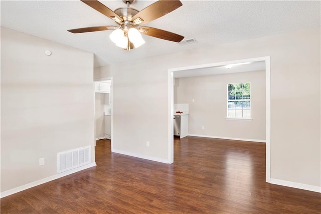 spare room featuring ceiling fan, dark hardwood / wood-style floors, and a textured ceiling