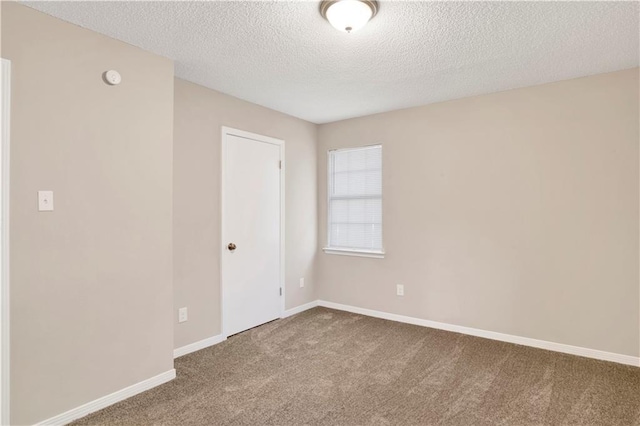 spare room featuring carpet flooring and a textured ceiling