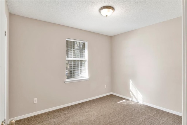 carpeted empty room featuring a textured ceiling