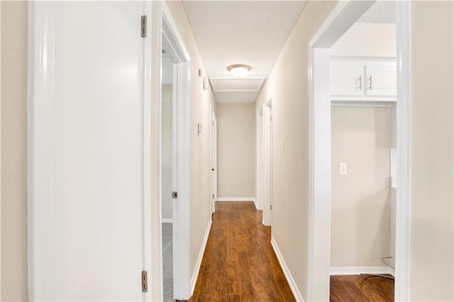 hallway featuring dark hardwood / wood-style floors and a textured ceiling