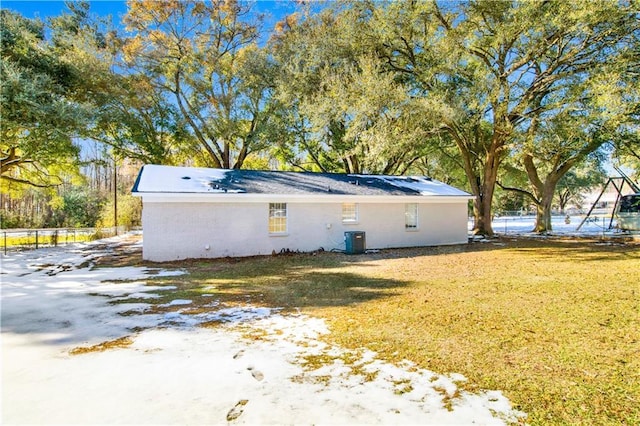 view of side of property featuring a yard and central air condition unit