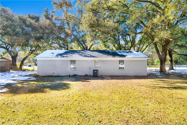 back of property with cooling unit and a lawn