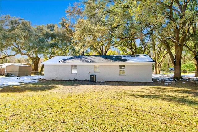 back of property featuring central AC and a lawn