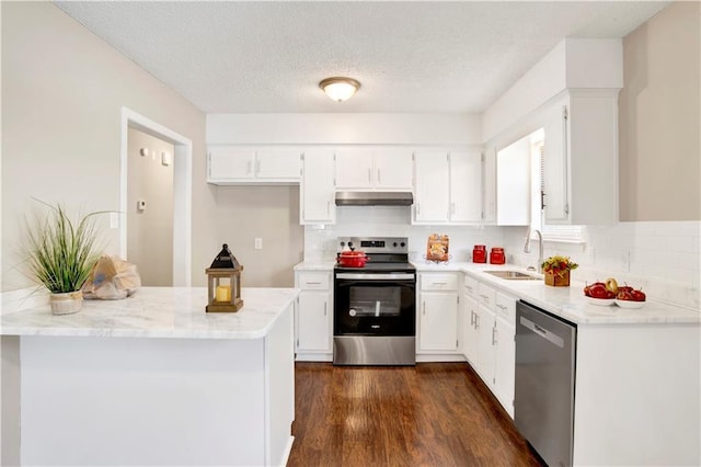 kitchen featuring sink, appliances with stainless steel finishes, white cabinetry, dark hardwood / wood-style floors, and light stone countertops