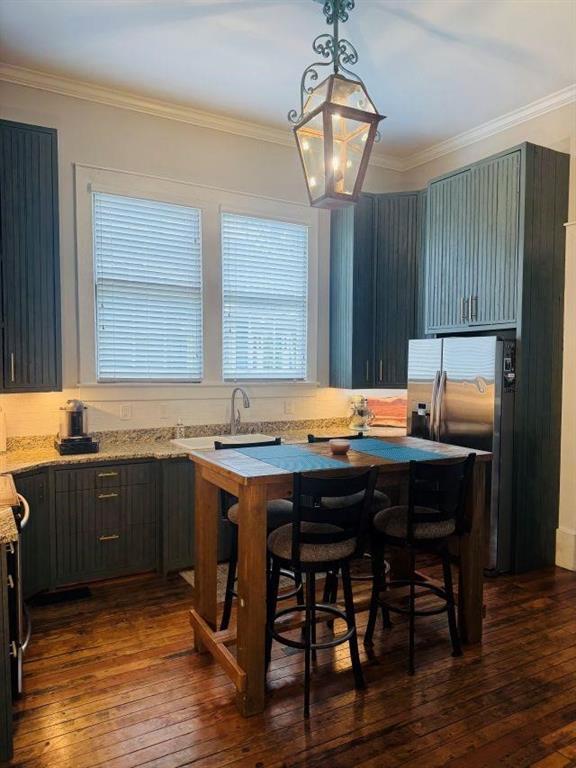 kitchen featuring a sink, crown molding, stainless steel refrigerator with ice dispenser, and dark wood-type flooring