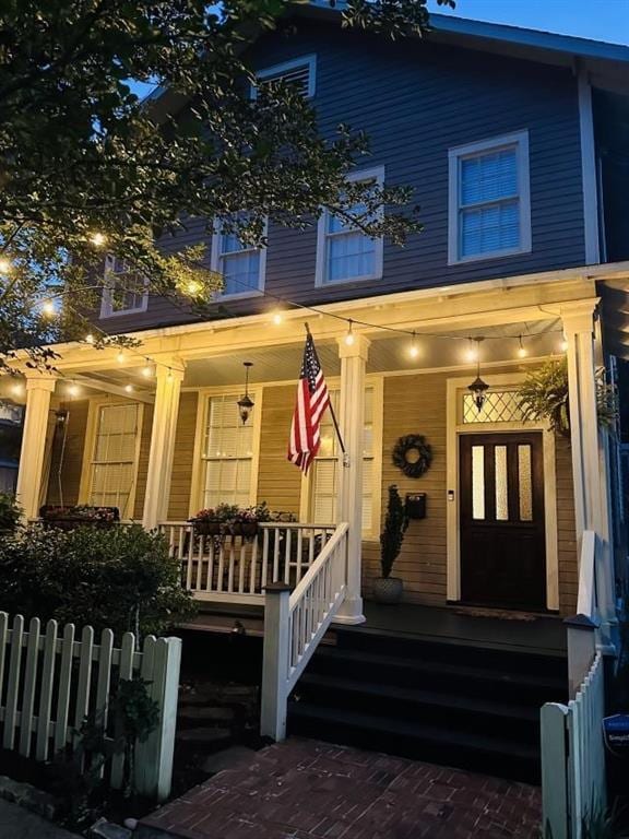 view of front of property featuring covered porch and fence