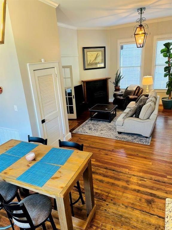 dining room with a wealth of natural light, ornamental molding, and hardwood / wood-style flooring