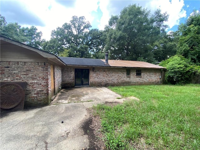 back of house featuring a patio area and a lawn