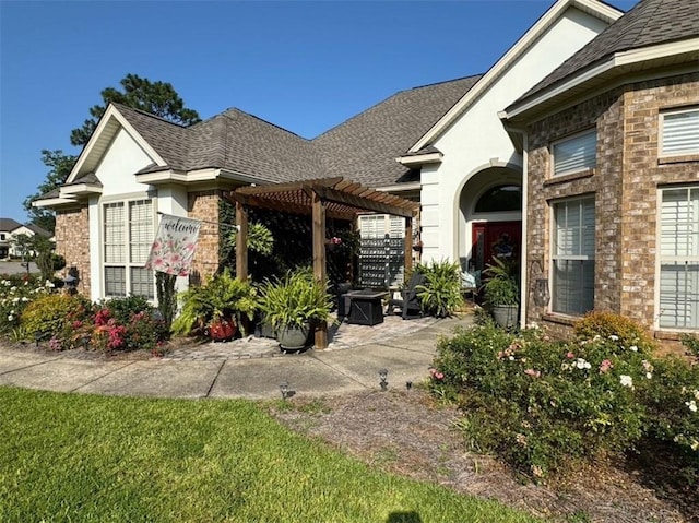 5541 Riverwood Lndg, Theodore, AL 36582 - view of front of property featuring a pergola, a patio, a shingled roof, and brick siding