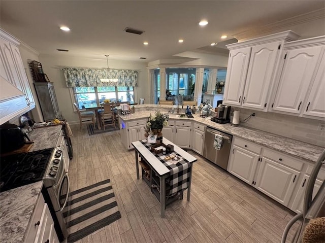 5541 Riverwood Lndg, Theodore, AL 36582 - kitchen featuring stainless steel appliances, crown molding, white cabinets, a peninsula, and a chandelier