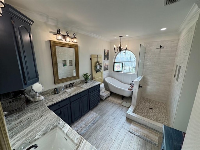5541 Riverwood Lndg, Theodore, AL 36582 - full bathroom featuring a soaking tub, vanity, a tile shower, wood finished floors, and a chandelier
