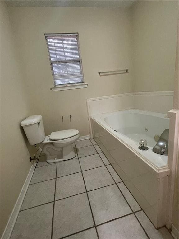 bathroom with tile patterned flooring, a relaxing tiled tub, and toilet