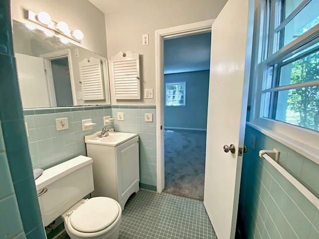 1313 Innsbruck Dr, Mobile, AL 36608 - bathroom with tile walls, tile patterned floors, toilet, vanity, and wainscoting