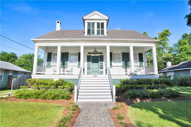 view of front of house featuring covered porch, stairway, a chimney, and a shingled roof