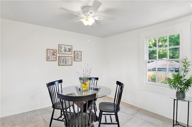 dining area featuring a ceiling fan and baseboards
