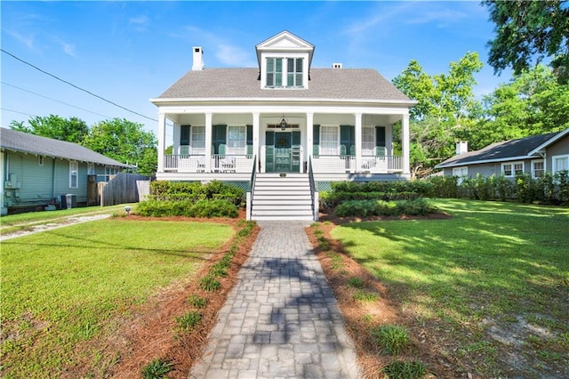 bungalow featuring a porch, a front yard, a chimney, and stairway