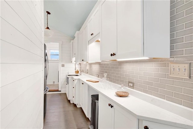 kitchen featuring lofted ceiling, a sink, white cabinets, light countertops, and tasteful backsplash