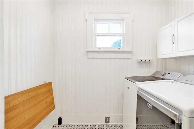 washroom with cabinet space, washer and clothes dryer, and tile patterned flooring