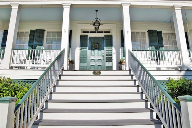 view of exterior entry featuring covered porch