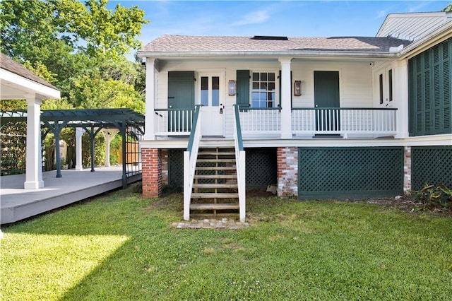 back of property featuring a yard, a pergola, and roof with shingles