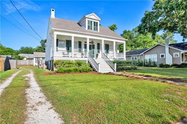 view of front of property featuring a porch, driveway, a chimney, and stairs