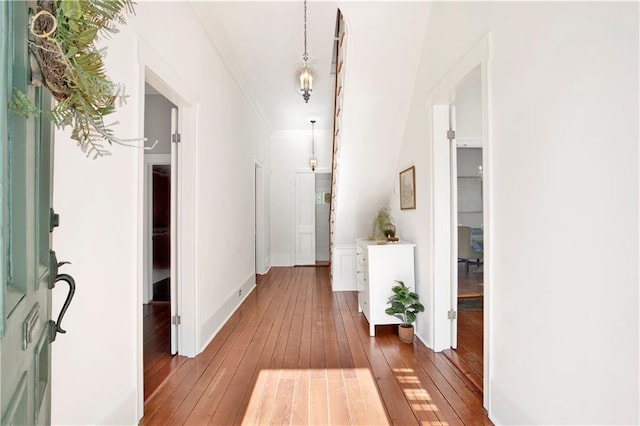 corridor with hardwood / wood-style flooring, crown molding, and baseboards
