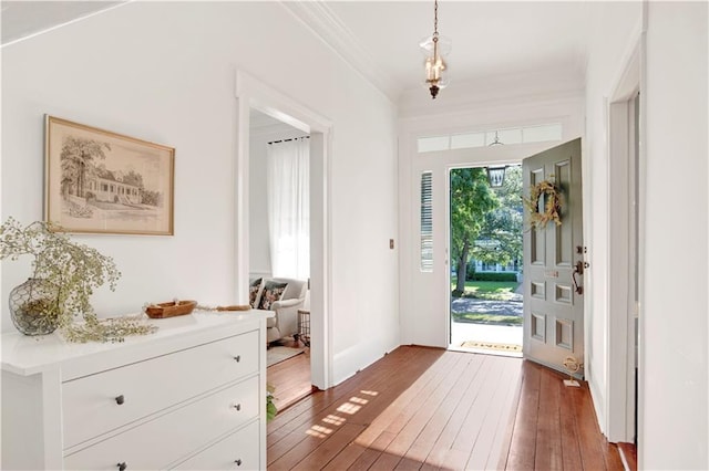 entrance foyer with hardwood / wood-style floors and ornamental molding
