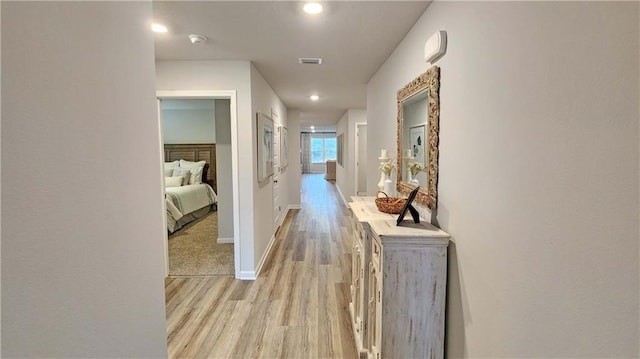 corridor with baseboards, recessed lighting, visible vents, and light wood-style floors