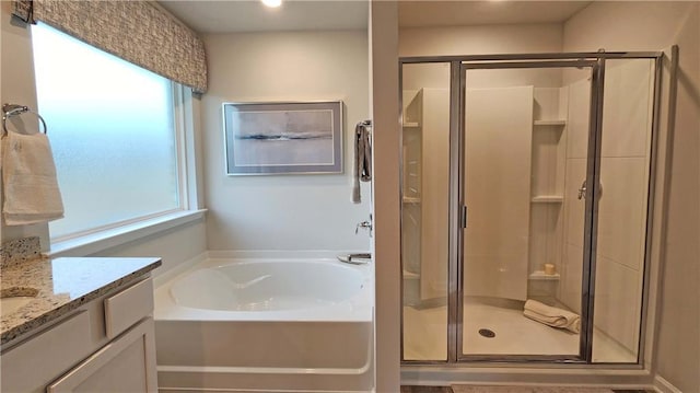 bathroom with a stall shower, vanity, and a bath