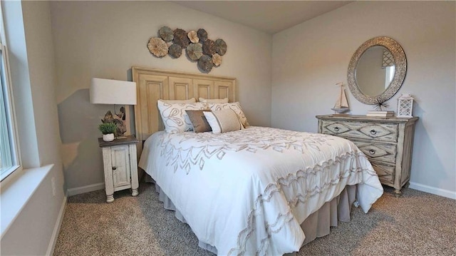 bedroom featuring dark carpet and baseboards