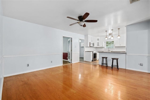 5175 Somerset Dr W, Mobile, AL 36619 - unfurnished living room featuring ceiling fan, light wood-type flooring, a sink, and baseboards