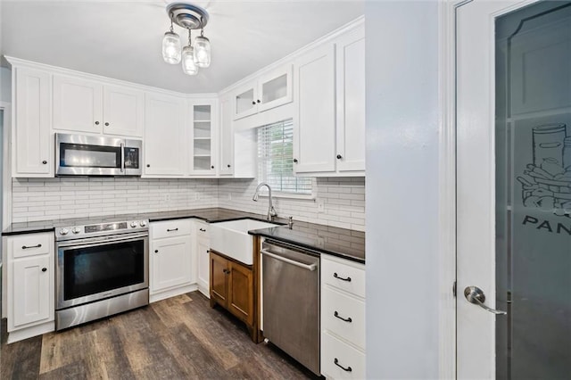 5175 Somerset Dr W, Mobile, AL 36619 - kitchen featuring appliances with stainless steel finishes, dark countertops, a sink, glass insert cabinets, and dark wood-style flooring