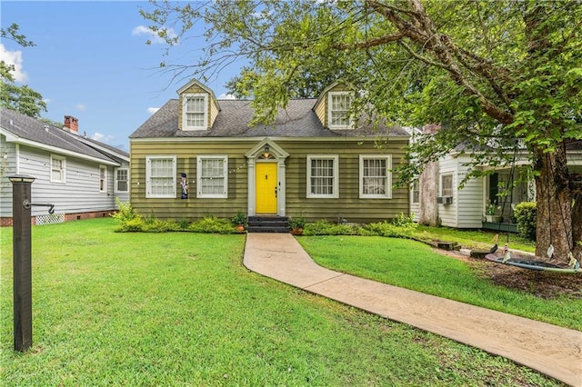 cape cod-style house with a shingled roof, a front yard, cooling unit, and entry steps