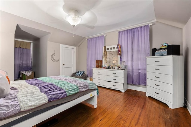 bedroom with a ceiling fan, vaulted ceiling, and wood finished floors