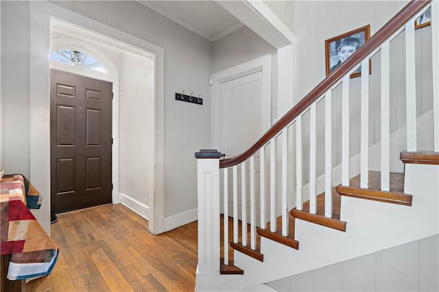 foyer featuring stairway, baseboards, ornamental molding, and wood finished floors