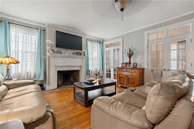 living room with light wood-style flooring, crown molding, and french doors