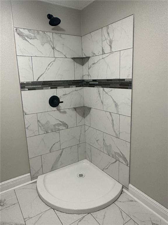 bathroom featuring a tile shower and tile flooring