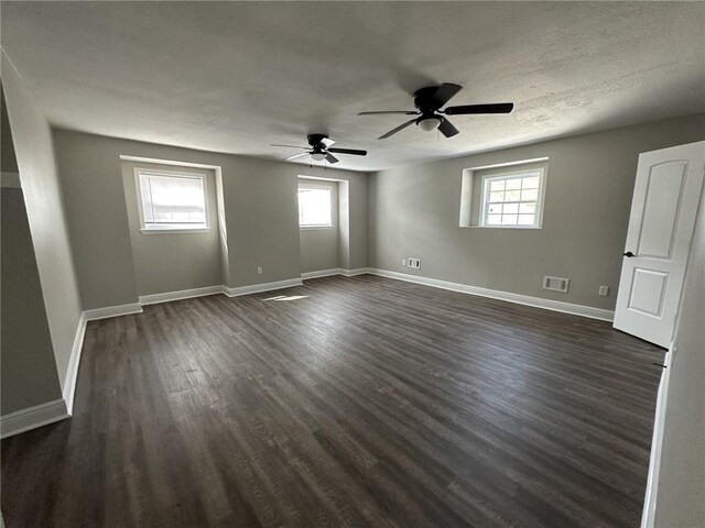 unfurnished room with ceiling fan, a textured ceiling, and dark hardwood / wood-style flooring