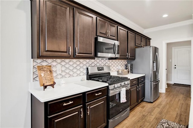 1484 Fenton Cir, Foley, AL 36535 - kitchen featuring appliances with stainless steel finishes, ornamental molding, tasteful backsplash, dark brown cabinetry, and light countertops