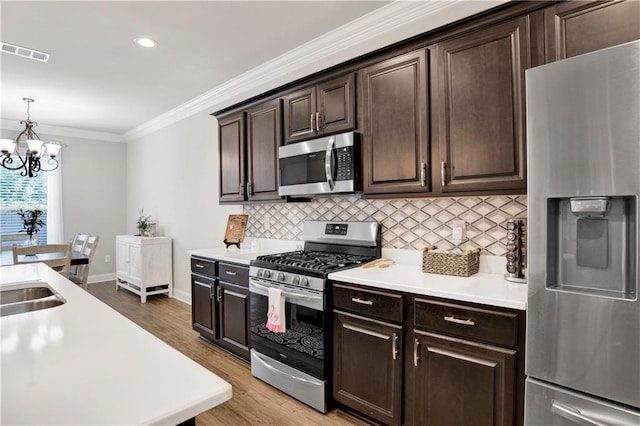 1484 Fenton Cir, Foley, AL 36535 - kitchen with stainless steel appliances, decorative backsplash, a chandelier, light countertops, and ornamental molding