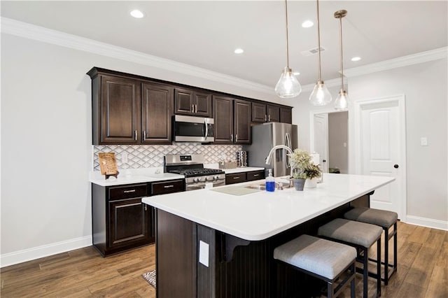 1484 Fenton Cir, Foley, AL 36535 - kitchen with appliances with stainless steel finishes, a kitchen breakfast bar, a kitchen island with sink, backsplash, and baseboards