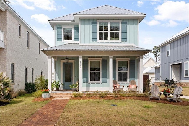 view of front of home with metal roof, a porch, board and batten siding, and a front lawn