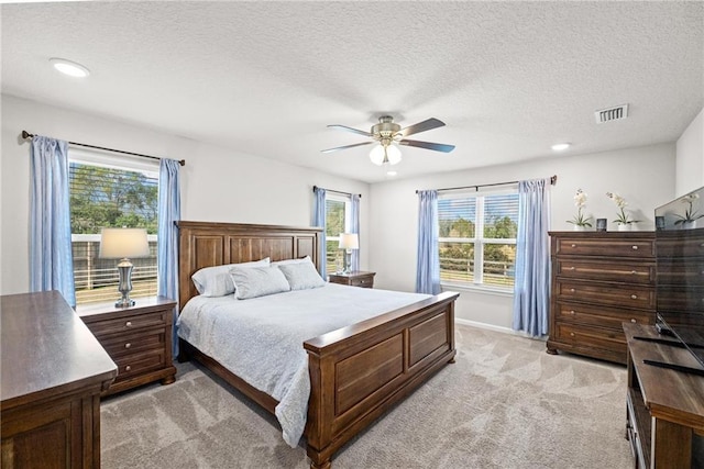 carpeted bedroom with ceiling fan and a textured ceiling