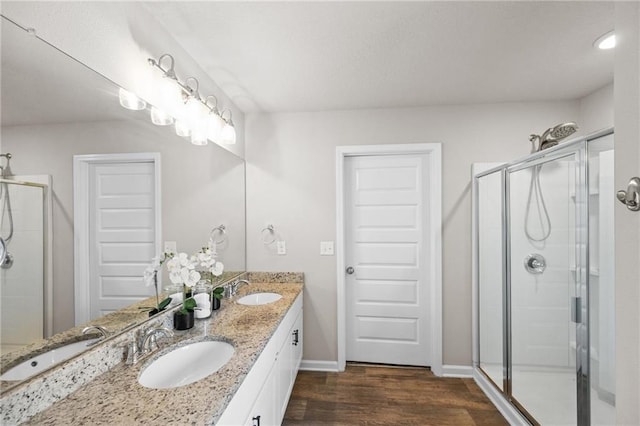 bathroom with wood-type flooring, vanity, and walk in shower