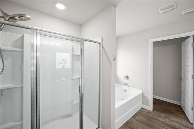 bathroom featuring hardwood / wood-style flooring and shower with separate bathtub