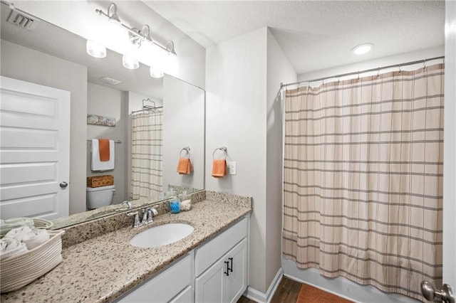 full bathroom with shower / tub combo with curtain, vanity, and toilet