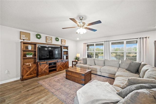 living room with wood-type flooring and ceiling fan